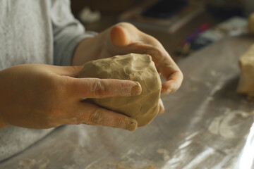 A woman makes a craft from clay