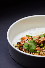 A plate of rice and vegetables on a table, a staple food dishware in cuisine