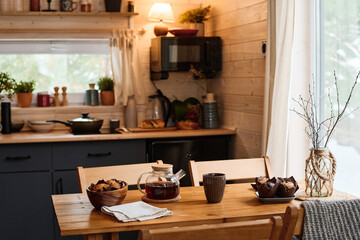 No people shot of part of cozy kitchen interior in modern wooden country house with muffins and tea...
