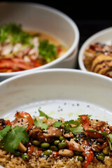 Close up of three bowls with fish ball, leaf vegetable, and plate on table