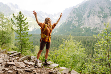 Portrait of a successful tourist on the mountain and enjoying freedom. Concept of trekking, active...