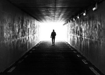Ghent, Flanders, Belgium -  Concept photo of a male man walking through a dark tunnel