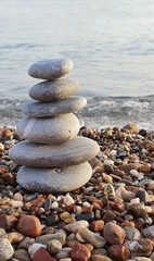 Fototapeta na wymiar Spa stones balance on the sand of the beach.