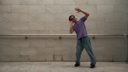 Motion shot of hipster listen music while move or dance to music at dancing room. Attractive street...