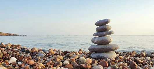 Tuinposter Spa stones balance on the sand of the beach. © Swetlana Wall