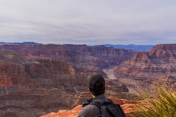 A man enjoys the spectacular view of red mountains at Grand Canyon West. One of the world heritage,...