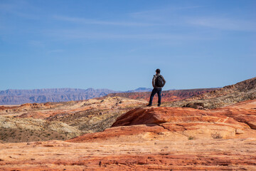 A man is standing and enjoying the spectacular view of Valley of Fire. It is one of geologic...