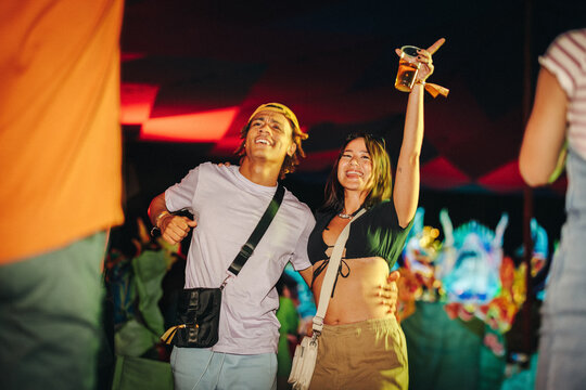 Festival partying: Young couple celebrating and dancing to the music at a festival