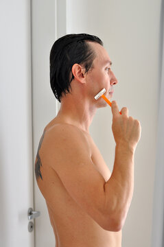 homem com gilete tirando a barba 
