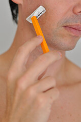 homem com gilete tirando a barba 