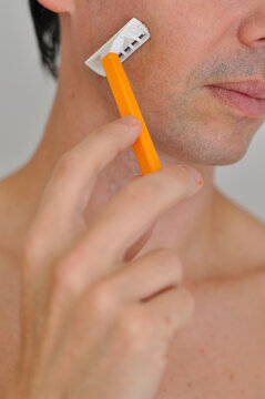 homem com gilete tirando a barba 