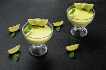lemon mousse in a bowl decorated with lemon slices. on a black background