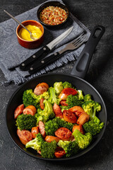 fried juicy sausage and crispy broccoli in skillet
