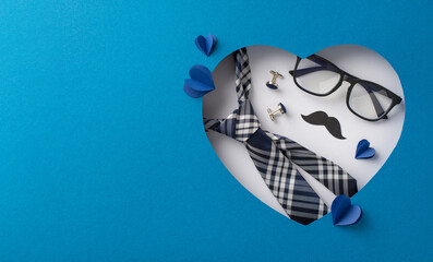 Creative Father's Day flat lay with a stylish tie, glasses, and mustache set against a heart-shaped...