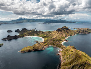 Aerial image of sunny Padar island with clouds passing over the beautiful pink beaches and bays in Komodo national park, Indonesia