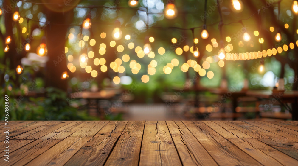 Poster festive atmosphere with warm bokeh lights above a rustic wooden table in an outdoor setting