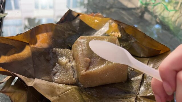  Vietnamese Chung Cake isolated on white. square glutinous sticky rice cake, stuffed with pork meat, green beans and wrapped in bamboo leaf. Traditional Vietnamese New Year Tet food.