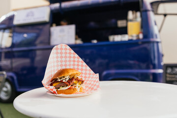 Gourmet burger served at a vibrant food truck setup
