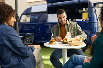 Enjoying a Casual Meal Outside a Blue Food Truck