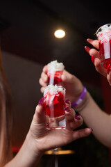 Group cheers with shot glasses of Paulaner hefeweizen wheat beer at fun event