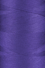 Texture of purple color threads in spool close up, macro. Sewing threads bobbin abstract...