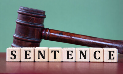 SENTENCE - word on wooden cubes on background of judge's gavel