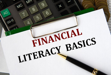 FINANCIAL LITERACY BASICS - words on a white sheet on the background of a calculator and a pen