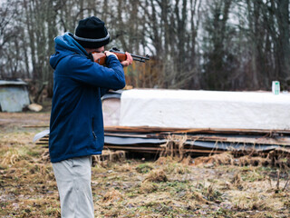 Man holding small caliber rifle for shooting practice in a country side. Sport and entertainment....