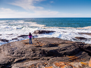 Teenager girl enjoy stunning nature of Kilkee coast and cliff, county Clare, Ireland. Rough...