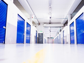 Self storage facility with blue color metal doors. Low angle of view. Selective focus. Light and...