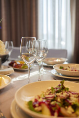 Table set with yellow tablecloth, plates of food, and wine glasses