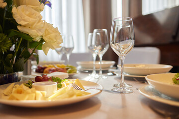 Table set with yellow tablecloth, plates of food, and wine glasses