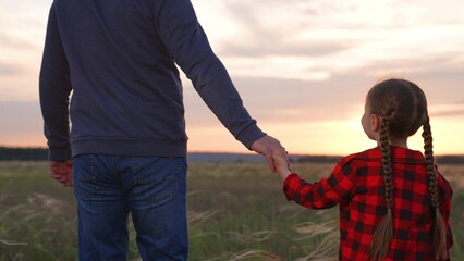 Daughter father holding hands at sunset. Little kid child baby man daddy strolling forward together...