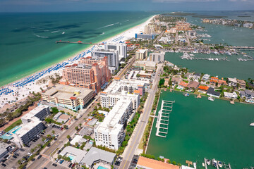 Clearwater beach Florida. View of beautiful ocean from drone. Tropical vacation. Summer coast for boating. Tourist spot with waves and white sand. Town with landscapers downtown. Sunset resort.