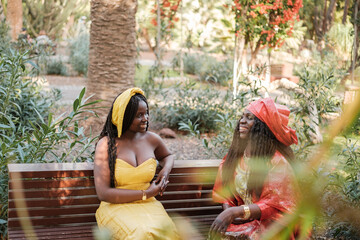 Mother and daughter chatting in their traditional African costumes at a ceremony. party, religion