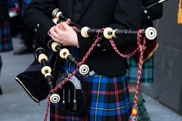 Traditional scottish bagpiper in tartan kilt