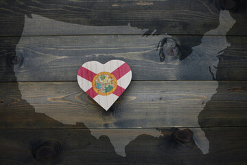 wooden heart with national flag of florida state near united states of america map on the wooden...