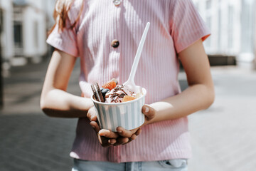 Portrait of a beautiful caucasian girl having ice cream in the city.