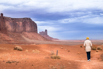 Lone hiker on Wildcat Trail, Monument Valley, with storm clouds