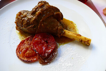 Lamb shank and grilled tomato for lunch