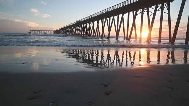 Rosarito Beach, Baja California, sunset in Playas de Rosarito with Pacific ocean waves lapping against the pier.