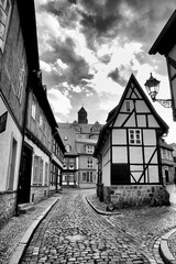 A quaint street view in Quedlinburg, Germany, reveals charming half-timbered houses lining...