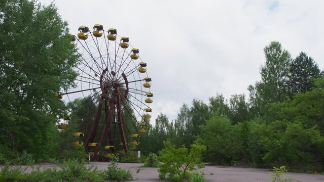 Abandoned Ferris wheel in the city of Pripyat. The whole playground was overgrown with greenery and trees. Consequences of the Chernobyl disaster.