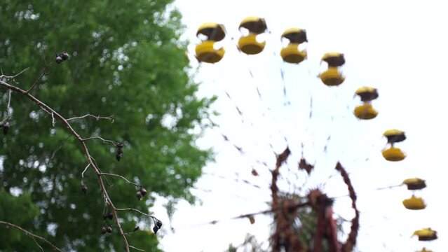 Abandoned Ferris wheel in the city of Pripyat. The whole playground was overgrown with greenery and trees. Consequences of the Chernobyl disaster.