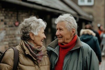 Portrait of a happy senior couple walking in the street. Focus on the woman