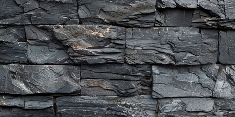 A wall made of black stone with a rough texture