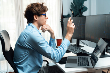 Working young business trader looking on laptop on laptop and pc in market stock graph investing in...