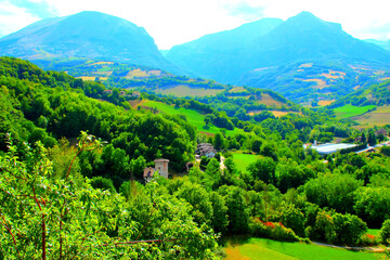 Detailed scene from Montefortino with sparkling vegetation in the foreground, buildings and roads,...