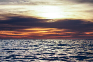 sunset over the sea nature background, backdrop, wallpaper, calm ocean ripples with light shining...