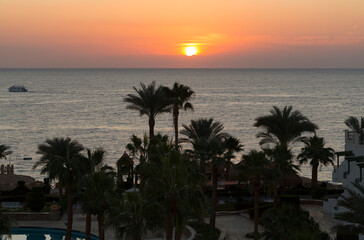 Obraz premium Sunrise on the sea coast. The movement of the sun and clouds across the sky. Park recreation areas of Egypt. Garden and landscape design.